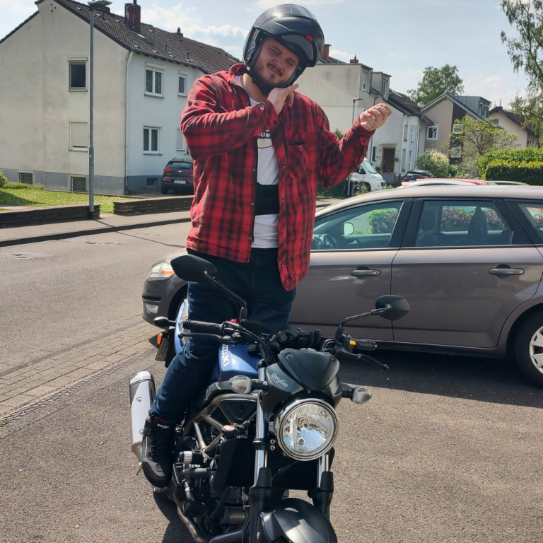 Fröhlicher Fahrschüler auf Motorrad